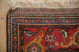Antique Kurdish rug corner showing the secured side cord, patterned kilim end, and original fringe.