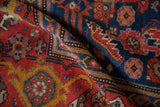 Hand-knotted texture of an antique Kurdish rug in navy, tomato red, and saffron.