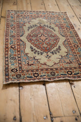Angled view of the hand-knotted pile on an antique Tabriz rug with a detailed floral border.