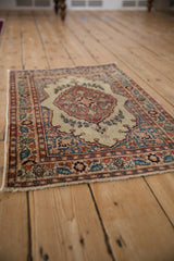 Antique Tabriz rug mat from a low-angle perspective, displaying its central medallion and floral borders.