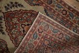 The folded corner of an antique Tabriz rug displays its hand-knotted foundation and secured selvage.
