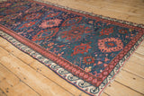 A long perspective on an antique Soumac runner reveals the scale of its colorful gul medallions and wave border.
