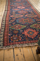 Angled view of a collector's Soumac runner showing its colorful repeating gul medallions.