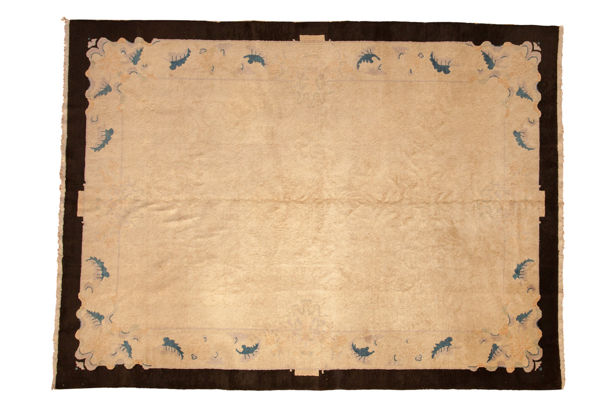Antique Chinese Art Deco carpet: ivory field, charcoal border with sapphire blue stylized motifs.