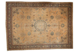 Antique distressed Yezd carpet featuring a roundel medallion, a sand-colored field, and intricate blue borders.