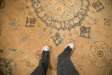Low, worn pile of a distressed antique Yezd carpet showing sand and sky blue floral patterns.