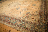 Angled view of the antique Yezd carpet's corner, detailing the floral border in jade green and sand.