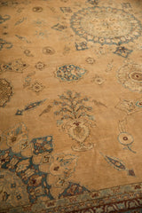 Detailed view of a germinating Tree of Life vased plant motif on a distressed, sand-colored antique Yezd carpet.