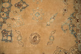 Detail of worn pile texture showing sky blue vased plant motifs on a sand-colored antique Yezd carpet.