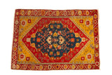 Antique Anatolian rug with a central sapphire medallion, pomegranate red field, and saffron yellow spandrels.