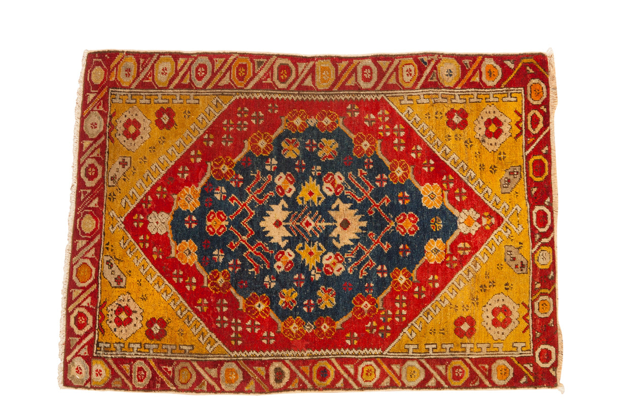 Antique Anatolian rug with a central sapphire medallion, pomegranate red field, and saffron yellow spandrels.