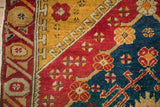 Geometric running-T border in saffron yellow alongside a pomegranate red and sapphire blue field of an antique Anatolian rug.