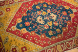 Rich texture of an antique Anatolian rug's sapphire blue medallion against its saffron yellow geometric border.