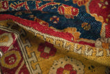 Antique Anatolian rug's hand-knotted pile with visible knot heads and red side cord.