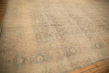 Angled view of a tea-washed Tabriz carpet showing the main turtle border and sandy field.