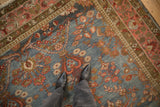 Worn pile and abrashed blue field of a distressed Mahal rug with pink and bronze palmette borders.