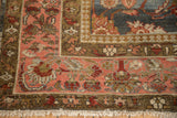 The palmette and floral blossom border in pink and bronze on the distressed corner of a vintage Mahal rug.