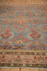 Low angle view of a distressed Persian Mahal carpet highlighting the abrashed blue ground and worn pile.