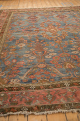 Low-angle view showing the distressed pile and tree of life motifs on a vintage Mahal rug.