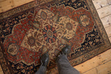A standing view showcasing the scale and low-pile texture of a vintage Farahan Sarouk rug.