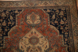 A corner detail of a vintage Farahan Sarouk showing the turtle samovar border motif.