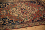 Angled view of a vintage Farahan Sarouk rug highlighting the low-pile texture and medallion details.