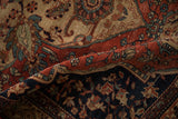 Close-up on a fold of the vintage Farahan Sarouk rug showing its hand-knotted texture and detailed motifs.