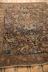 Angled view of the Farahan Sarouk rug's intricate vine pattern and time-softened low pile texture.