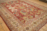 Angled view of an antique Mahal carpet's madder red field and detailed ivory turtle samovar border.