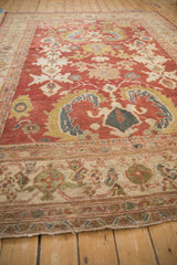Angled view showcasing the large-scale floral patterns and turtle border of an antique Mahal carpet.