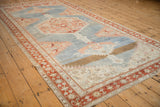 The distressed texture and geometric design of an antique Karabagh runner shown from a full length angle.