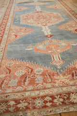 An antique Karabagh runner's serrated geometric medallions viewed from a low angle along its length.