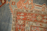 A folded corner of an antique Karabagh rug showing the reverse weave and the low, distressed pile.
