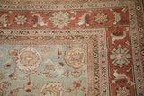 Mahal carpet corner with a decorative terracotta border and a dusty powder blue floral field.