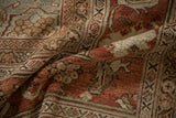 Soft, distressed low pile of a vintage Mahal carpet with terracotta florals and muted jade accents.