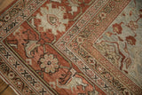 Corner detail of a distressed Persian Mahal carpet showing the worn texture of its terracotta border.