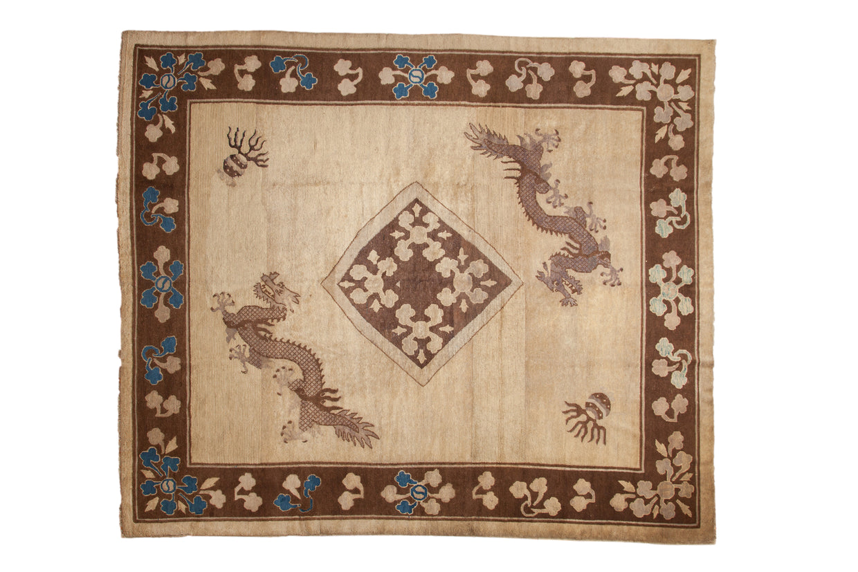 Antique Peking carpet with diagonal dragons, a central medallion, and a floral border in brown, camel, and blue.