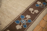 Detail of the antique carpet's border with sapphire blue and beige blossomed flowers on a brown ground.
