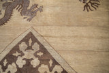 Five-toed dragon and floral border detail on the camel-toned pile of an antique Peking rug.