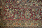 Evenly worn corner of a vintage Tabriz carpet, showing intricate floral borders in teal, burgundy, and beige.