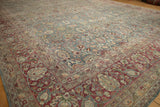Corner perspective on a vintage Tabriz rug, showing the burgundy border and dusty teal floral pattern.