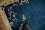 Antique Peking carpet showing the short pile, cobalt blue field, and a butterfly motif near the border.