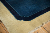 The scalloped corner contour of an antique Peking carpet in cobalt, navy, and ivory.