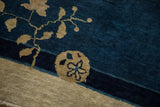 Beige pomegranate and vine detail on the cobalt blue pile of an antique Peking carpet.