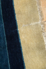 Historic repair on the short, beige pile of an antique Peking carpet.