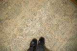 Close-up view of a distressed Kerman carpet showing its evenly worn low pile and faint foundation.
