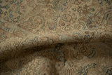 Evenly worn texture of a distressed Kerman rug with sandy and dusty blue floral vines.