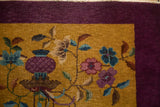 Stylized Art Deco florals on a low-pile gold field beside a solid aubergine border.