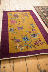 Angled perspective of a Nichols Art Deco rug showing its open composition and rich aubergine border.