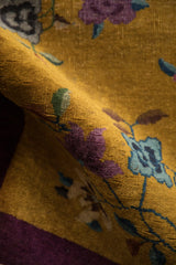 Detailed texture of a vintage Art Deco rug's gold pile showing knot heads and floral motifs.